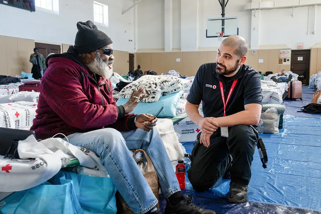 Rob Rivera taking to someone in a red cross shelter.